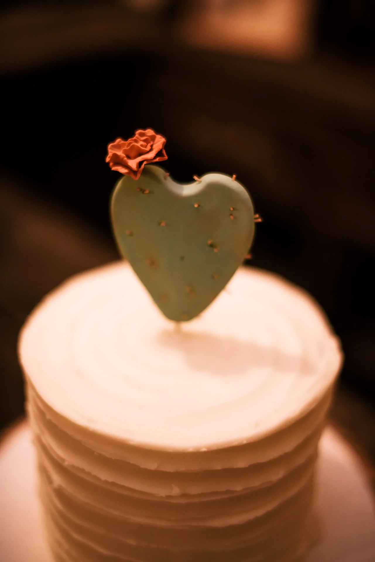 tiny red flower on heart shaped cactus topper captured by photographer during romantic wedding at the historic Leo Carrillo Ranch in Carlsbad California