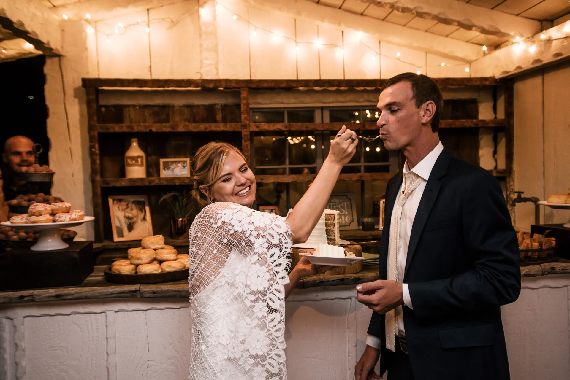 bride gives her husband a bite of cake captured by photographer during romantic wedding at the historic Leo Carrillo Ranch in Carlsbad California