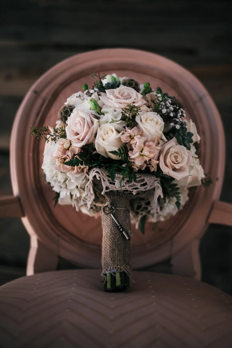 Wonderfully romantic White and Pink rose bouquet with burlap details and a vintage key.