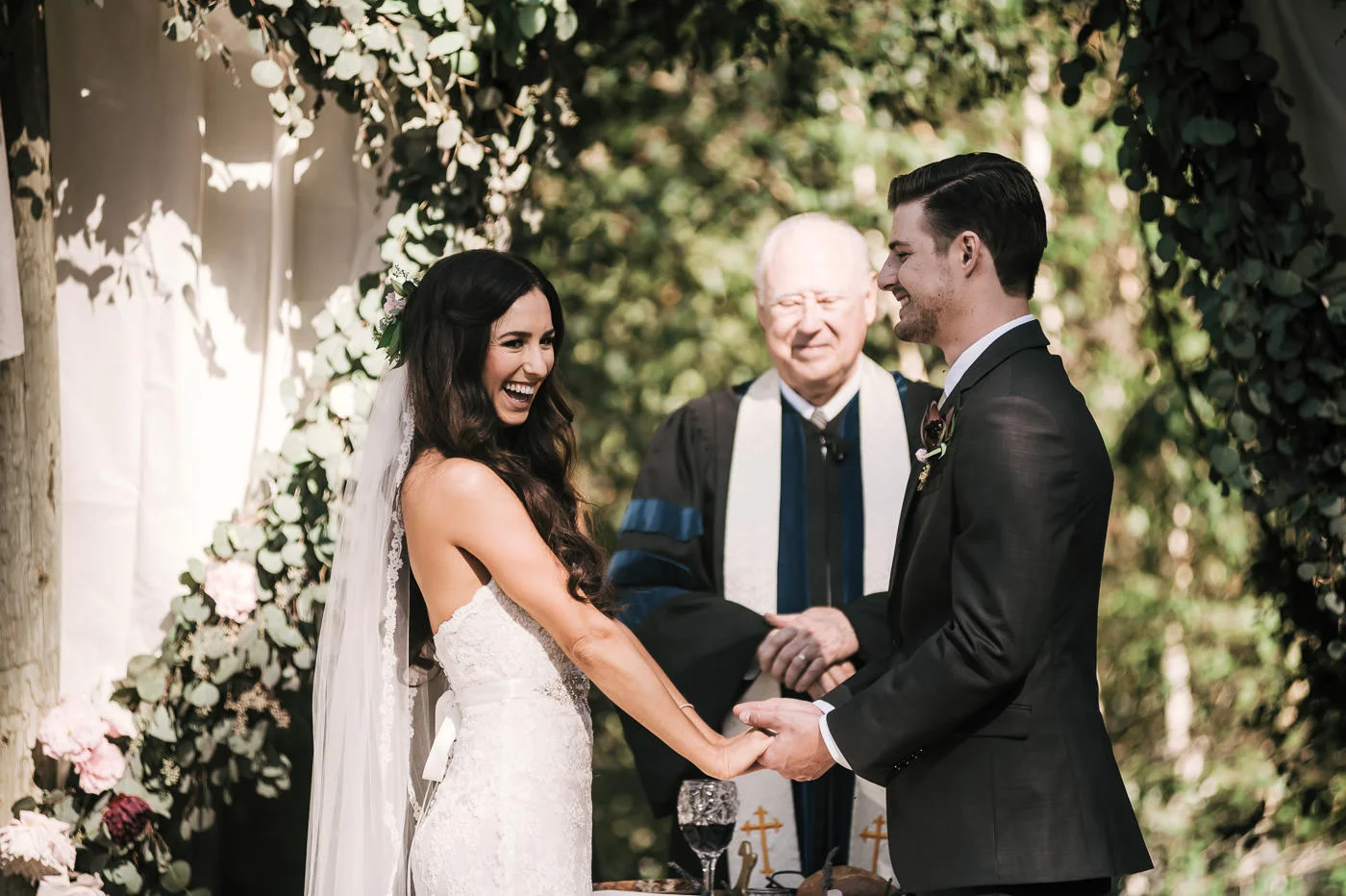 Bride luaghs with joy during wedding ceremony