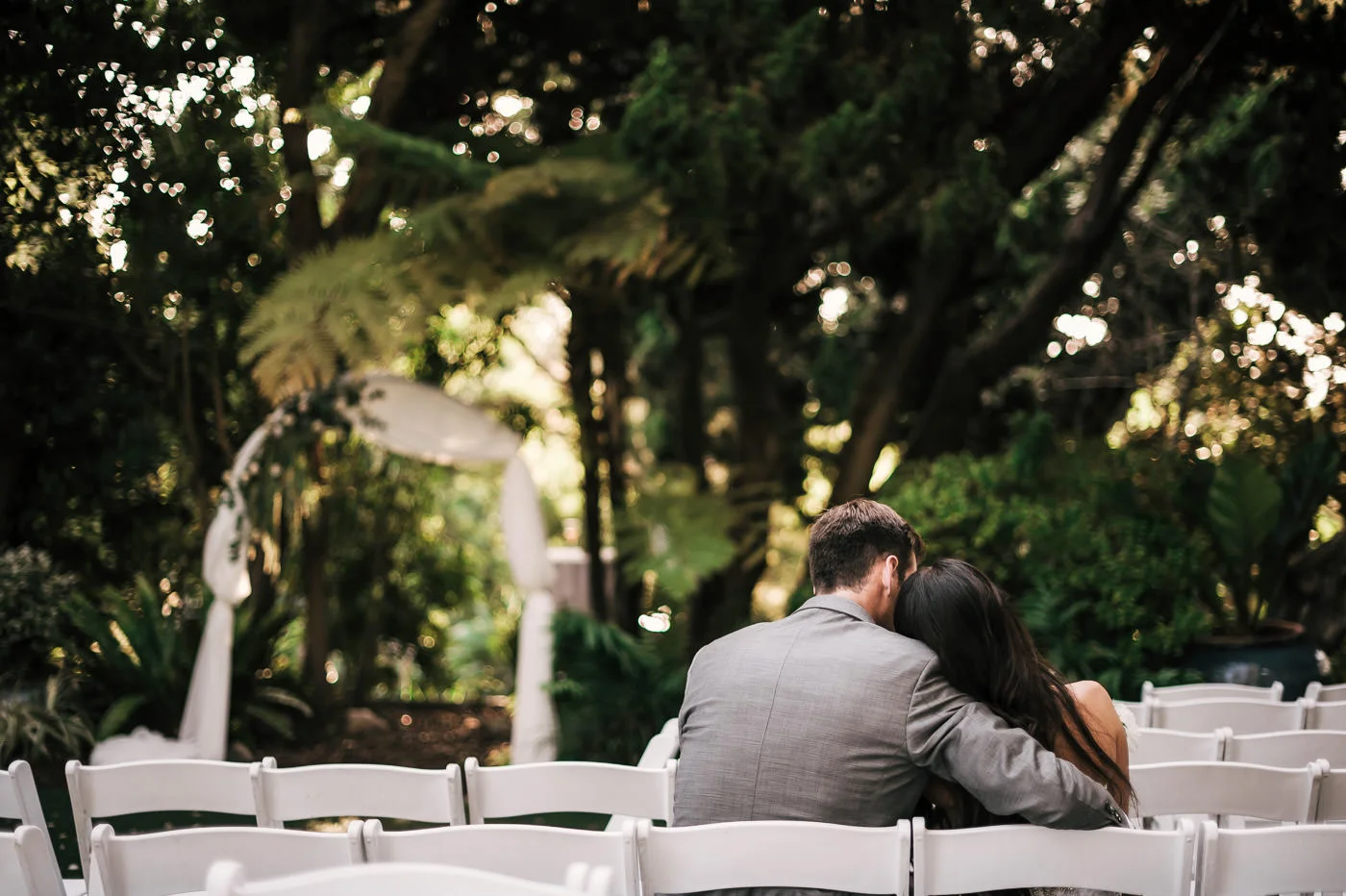 Bride and groom sit and enjoy a little peace and quiet after a romantic ceremony at the San Diego Botanical Garden.