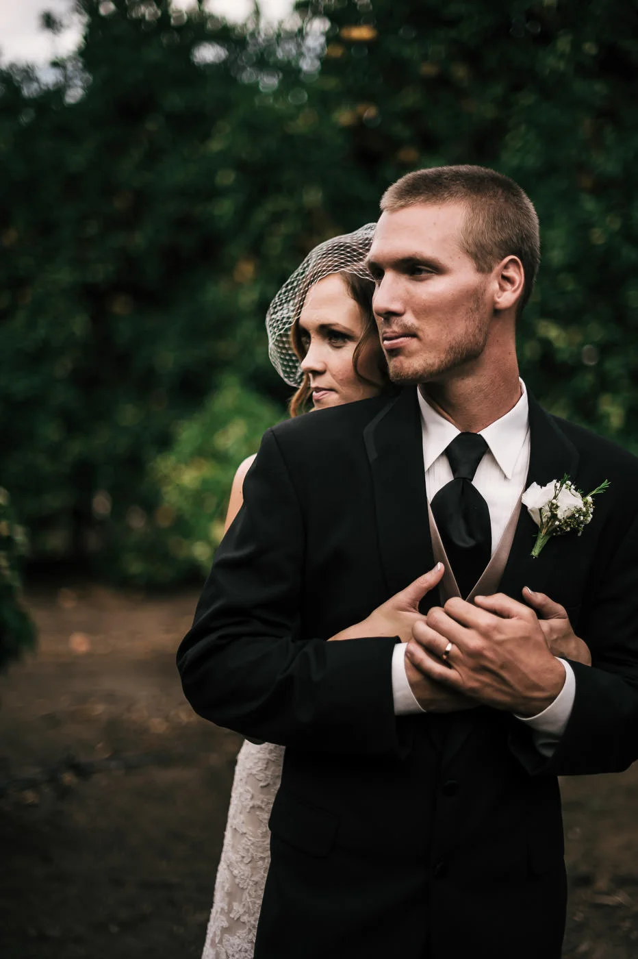 Couple holds each other tight as they enjoy a moment alone in the orange orchards of Temecula.