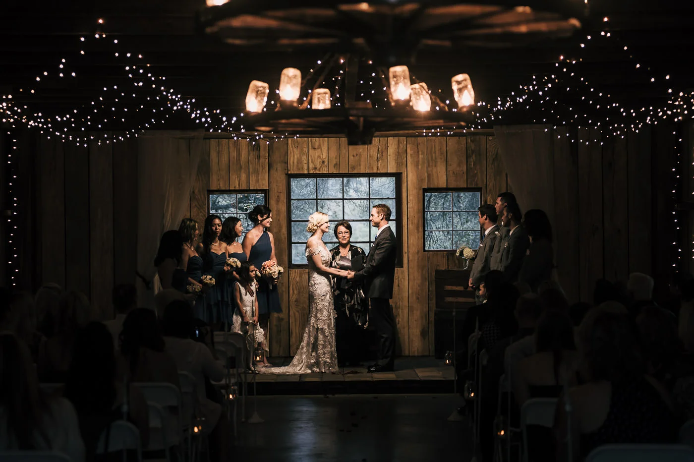 Romantic couple holds hands as they say their vows at a rustic wedding at Whispering Oaks Terrace in Temecula.