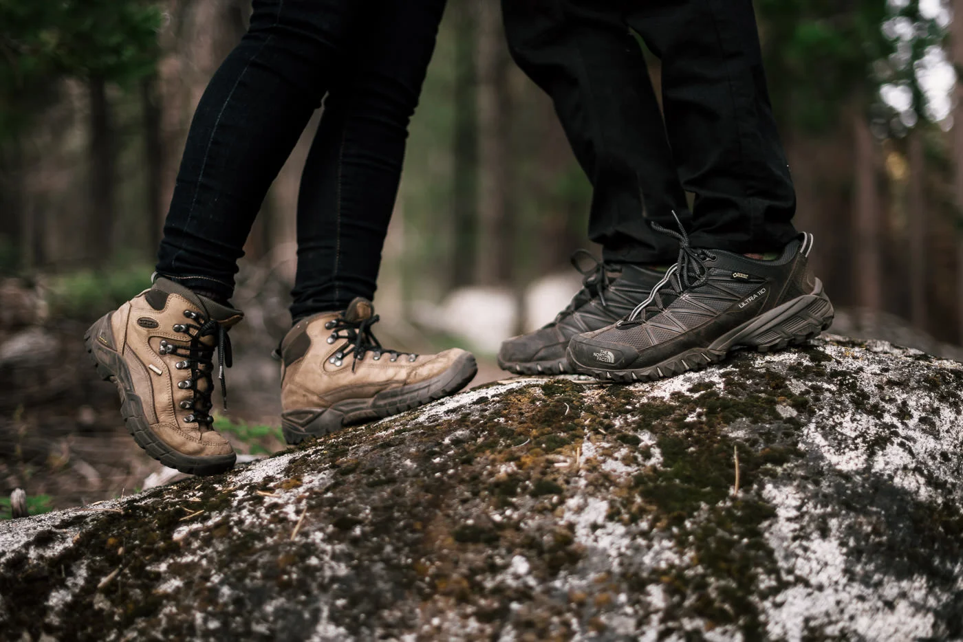 The hiking boots of two lovebirds sharing a kiss during their engagement session in Sequoia national park.