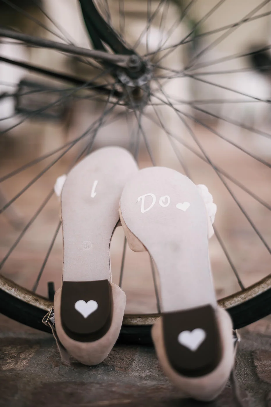 Brides wedding shoes with I do and heart stickers placed on the bottom.