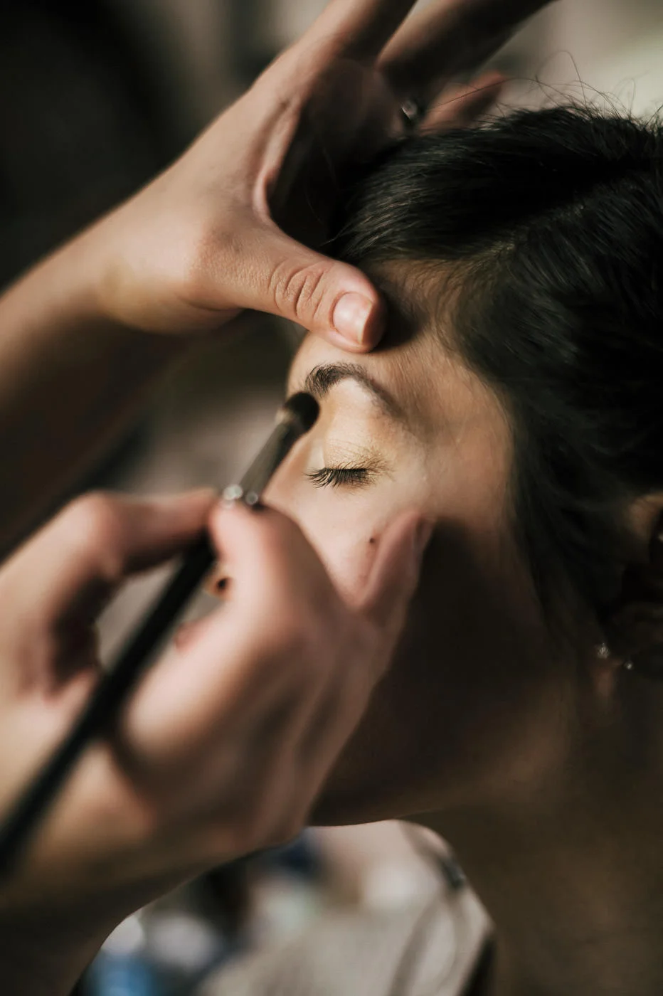 Makeup artist works on brides face before the big wedding in the temecula wine country