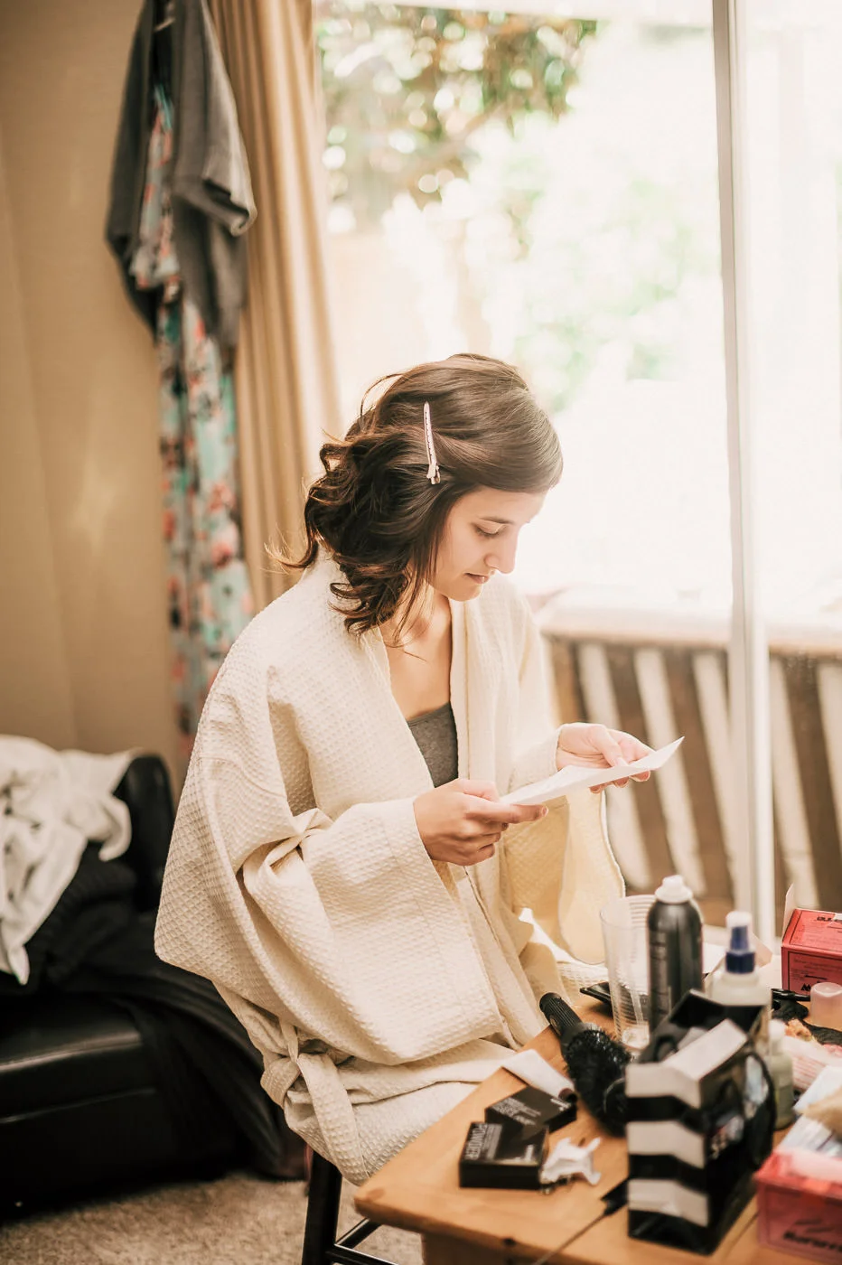 Bride opens a letter from her groom while getting ready for her romantic Temecula wine country wedding