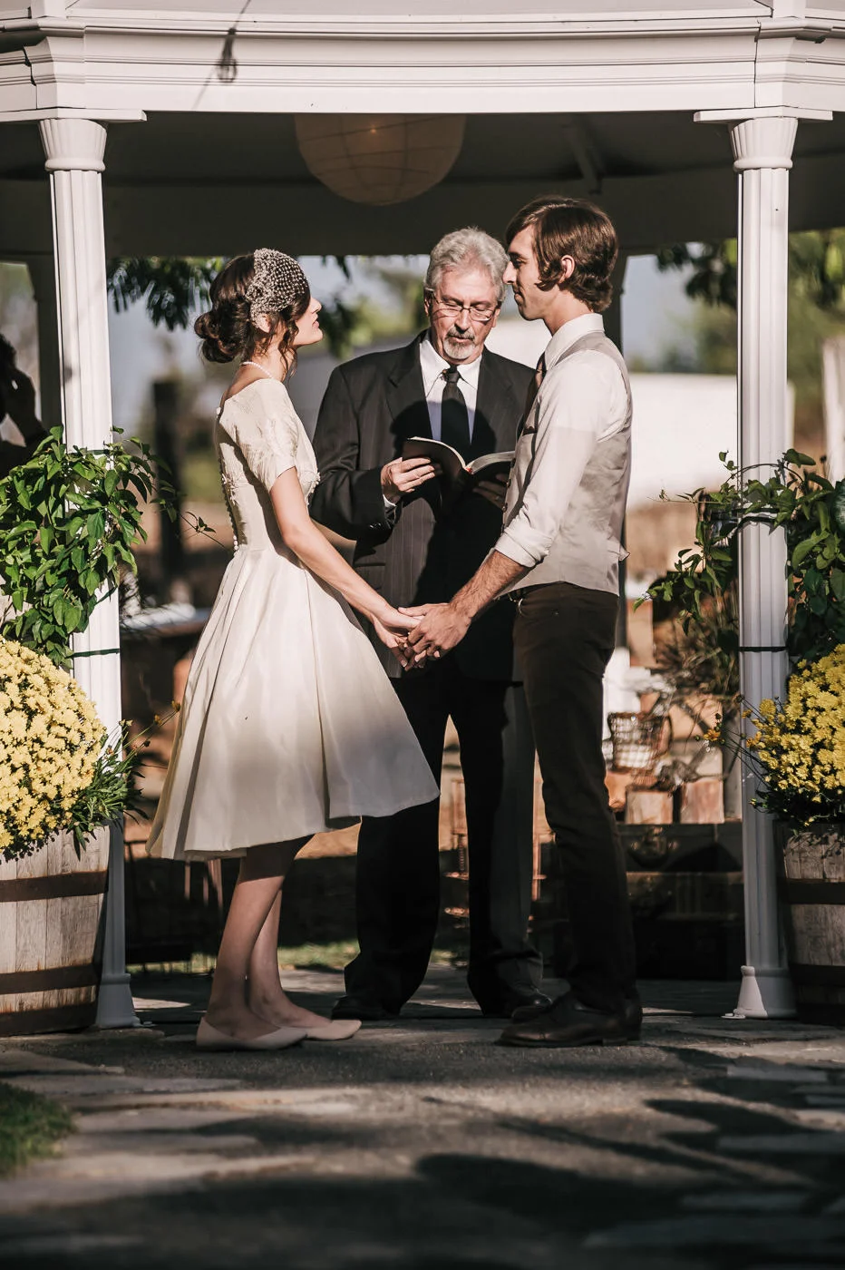 lovebirds hold hands an stare longingly into each others eyes as the minister conducts the wedding ceremony in Temecula California