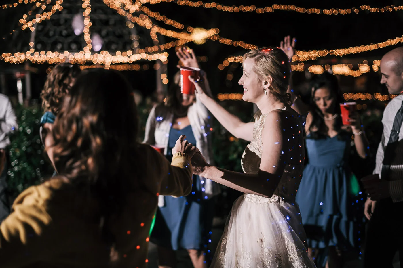 Bride celebrates with her guests under the twinkling lights of the whispering oaks terrace
