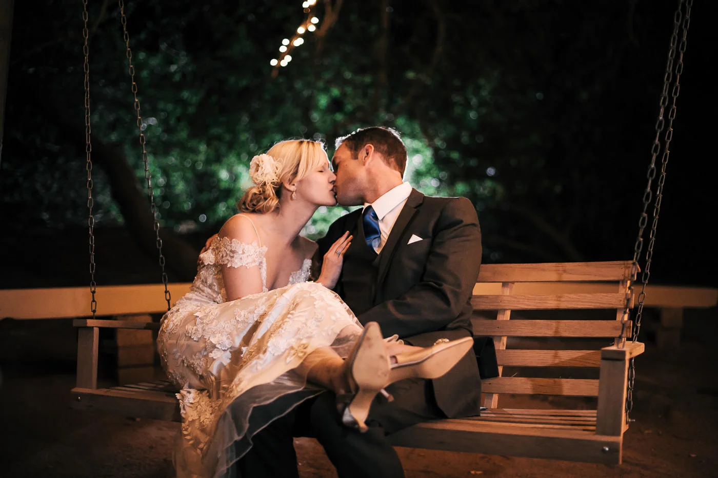 bride and groom enjoy a tender moment alone as they rock gently on a tree swing at whsipering oaks terrace