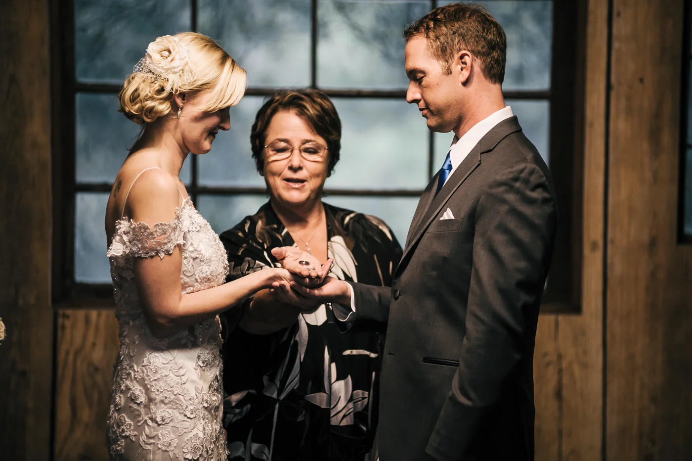 ministor presents the wedding rings to the bride and groom at their ceremony at whispering oaks terrace
