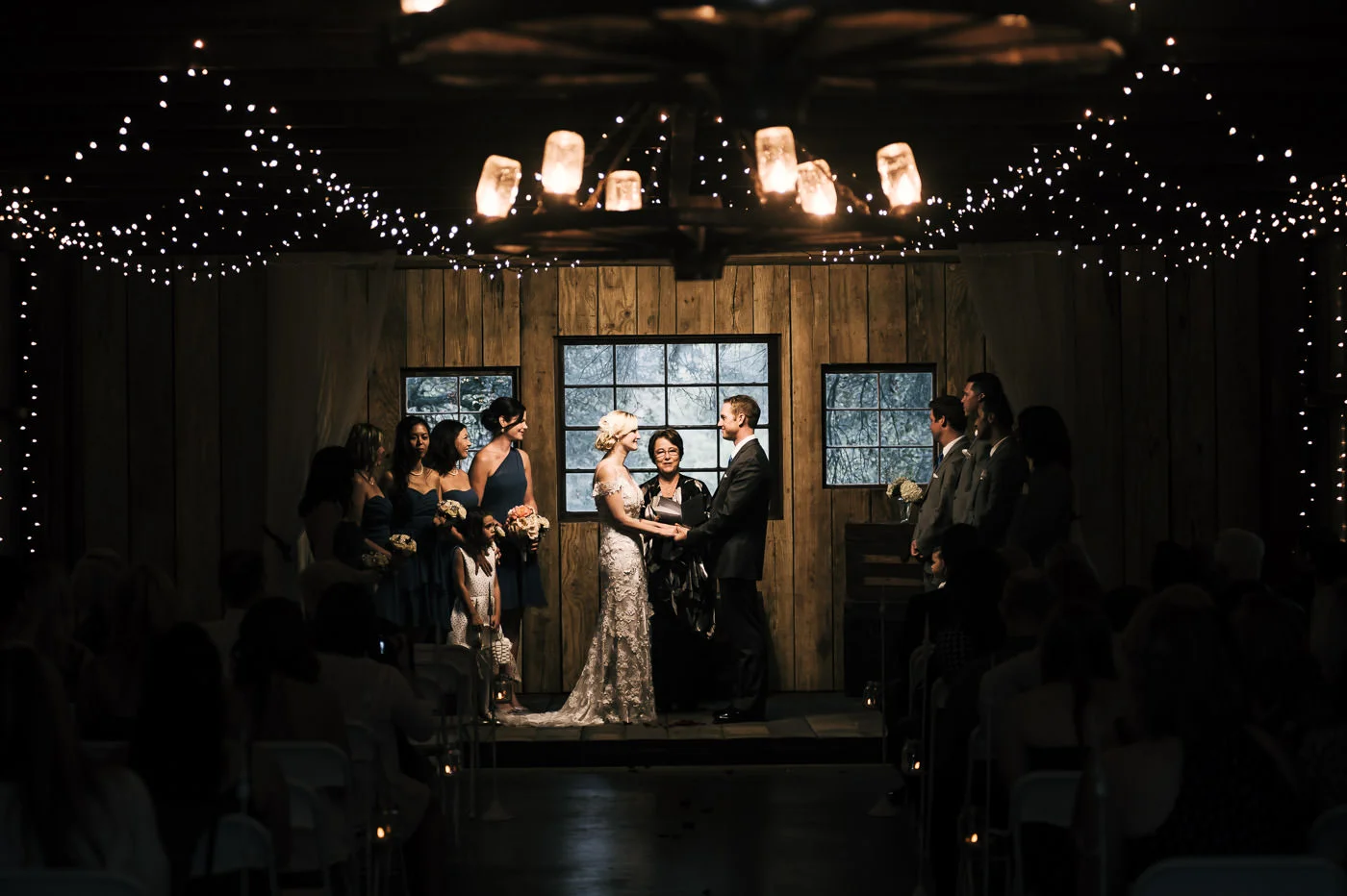 romantic couple holds hands as they say their vows at a rustic wedding at whispering oaks terrace in temecula