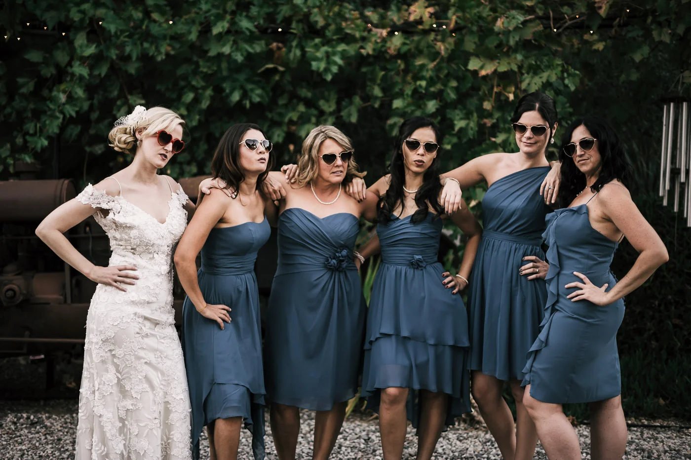 Bride and bridesmaids put on heart shapped sunglasses and strike a pose for photos at a Whispering Oaks Terrace wedding