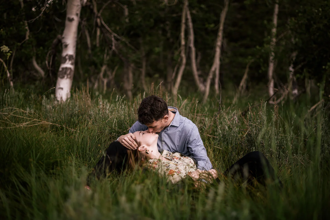 Couple kisses in a grassy meadow before the sun rises on their sequoia national park engagement