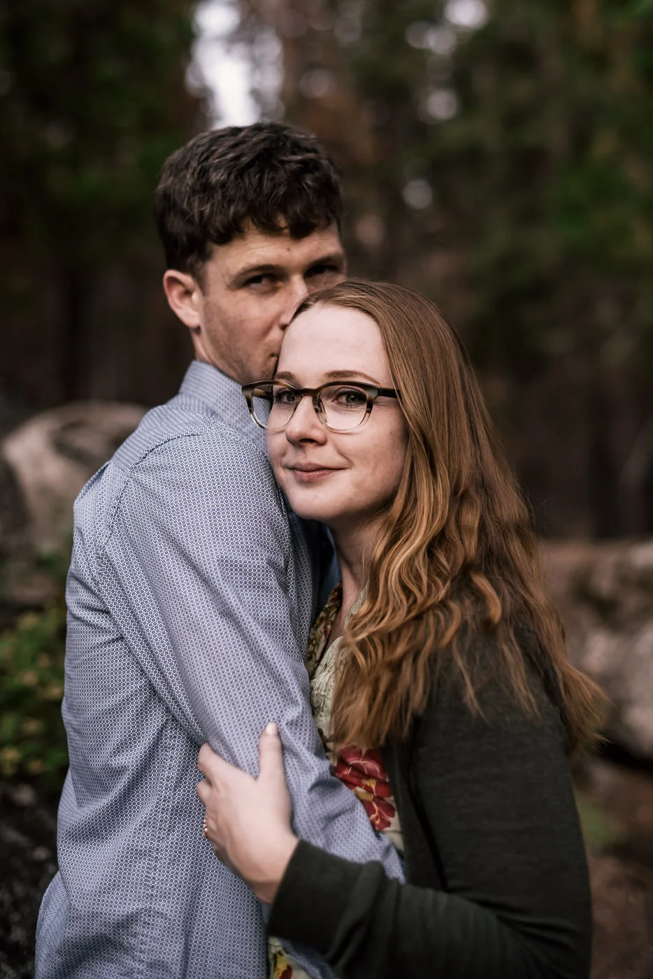 Happy soon to be married couple stops to hold each other close for a moment on the trail