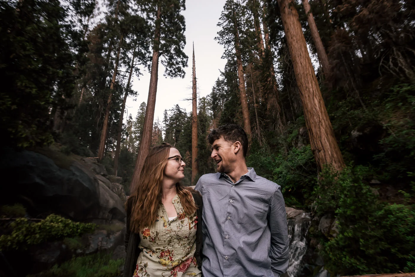 Towering Giant sequoia and a thundering waterfall surround this lovely couple on their engagement session in sequoia national park