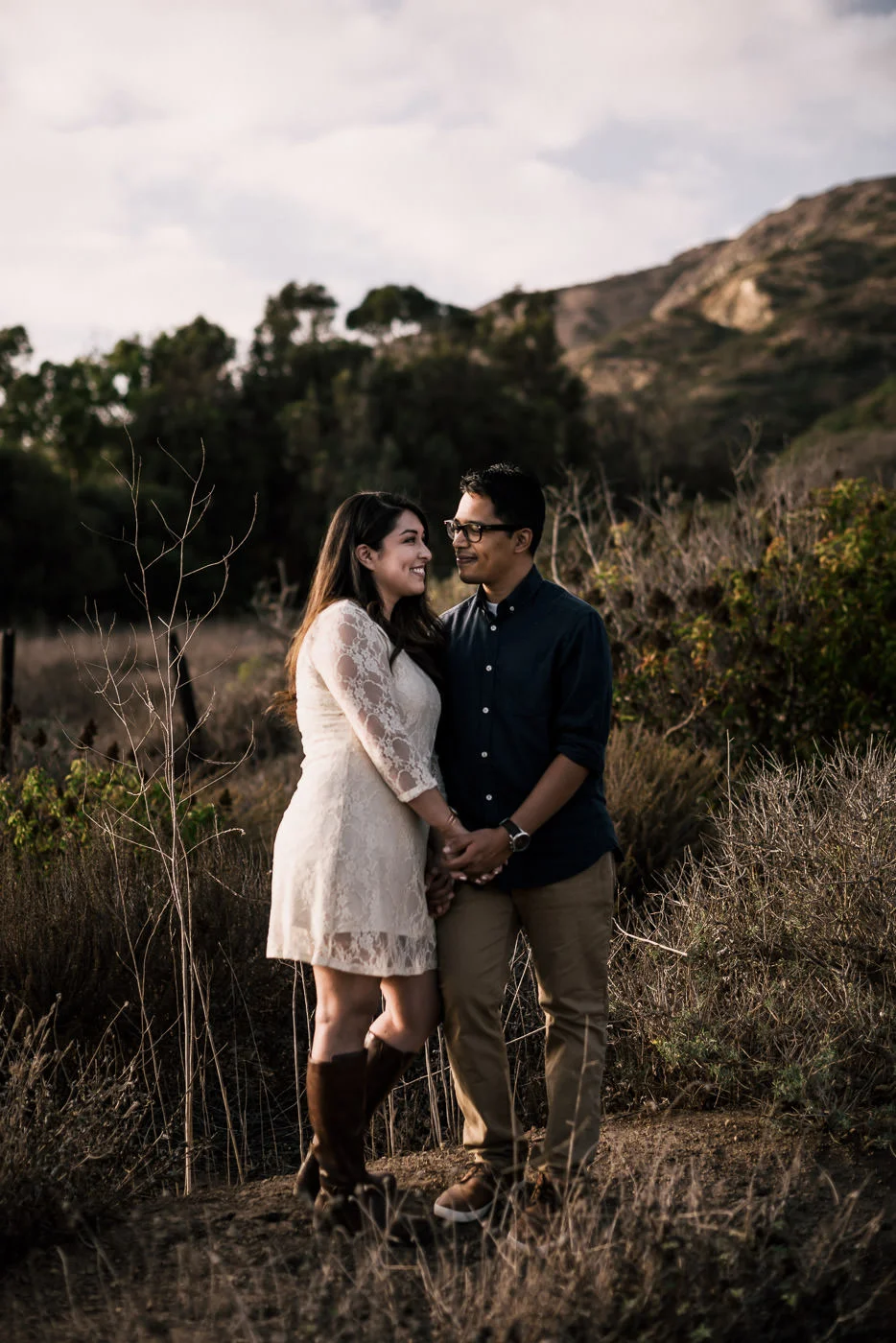 With hands clasped tightly a coupe gazes into each others eyes and smiles at their El Matador state beach engagement in Malibu.
