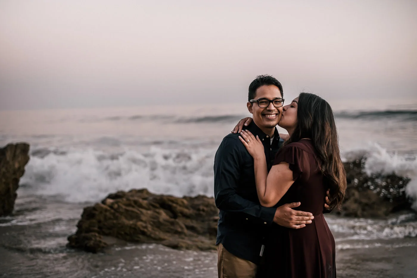 Loving kiss on the cheek as the waves crashed all around them on the beachs of Malibu.