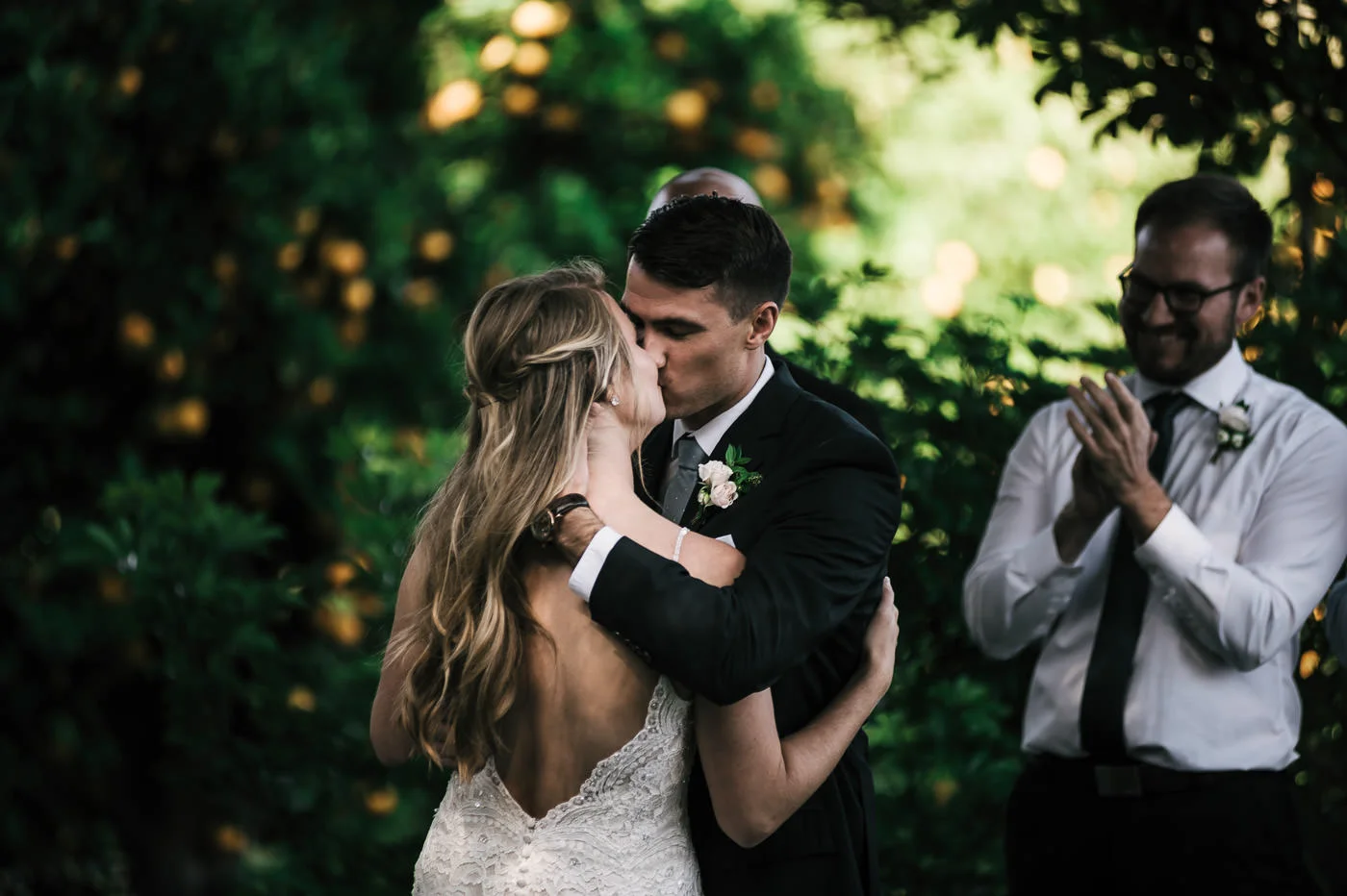The orange orchard made for a perfect backdground fot this romantic first kiss at a Temecula wedding.