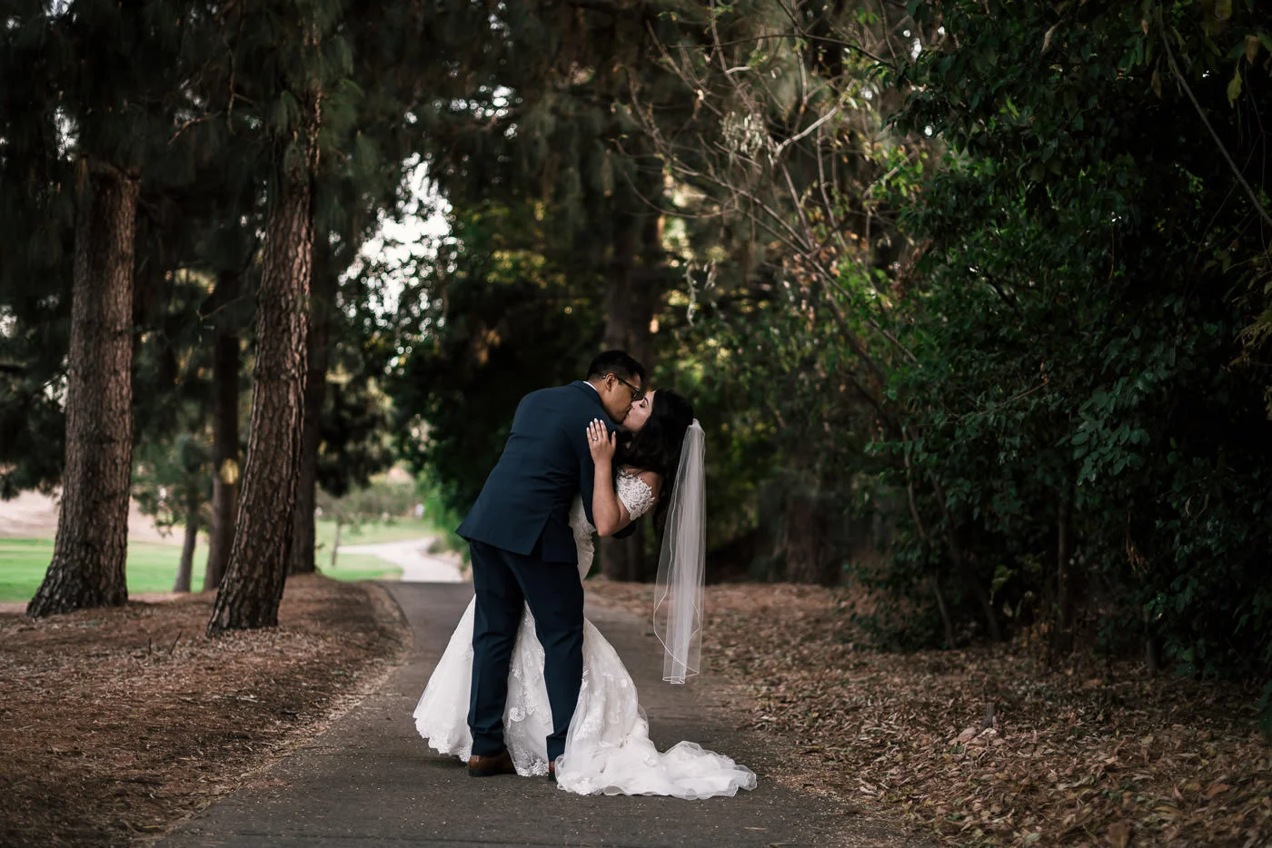 groom romantically kisses bride as he dips her after their wedding at the knollwood country club in granada hills