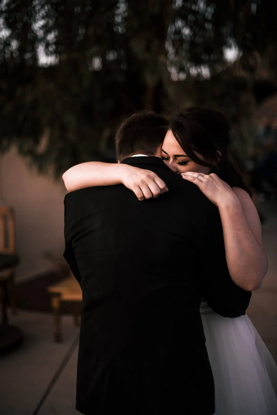 Sweet newlyweds have their first dance as the sun sets.