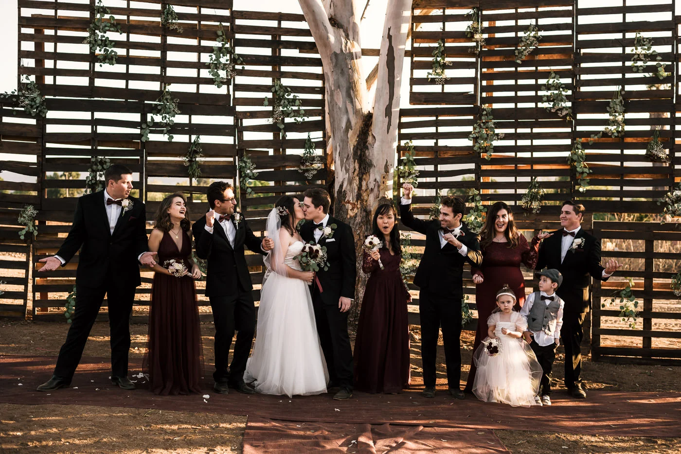 Wedding party cheers as the bride and groom kiss at their Temecula wedding.