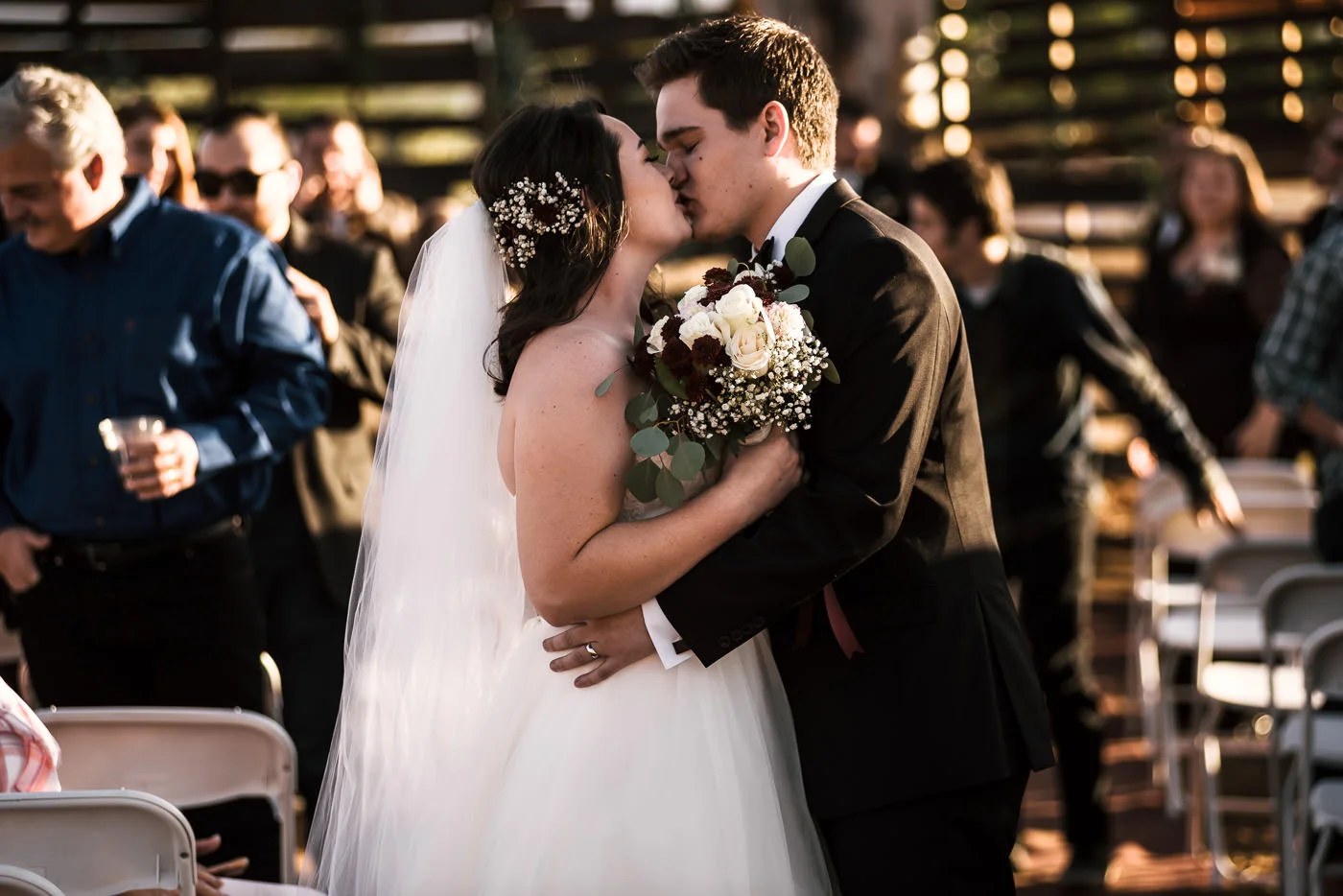 Newly weds kiss as they walk down the aisle at their Temecula Wine country wedding.