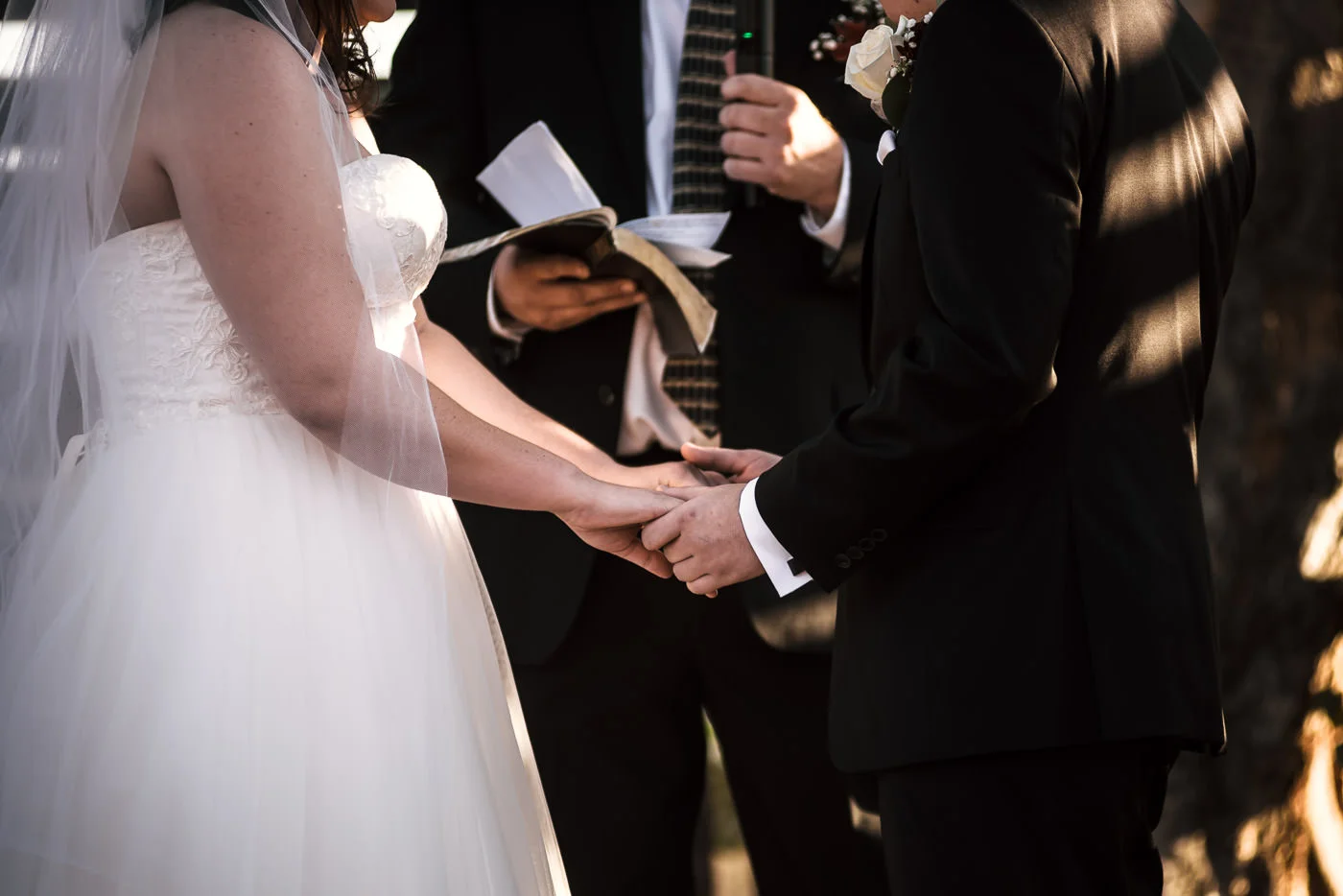 Couple holds hands as they say their vows at their country wedding.