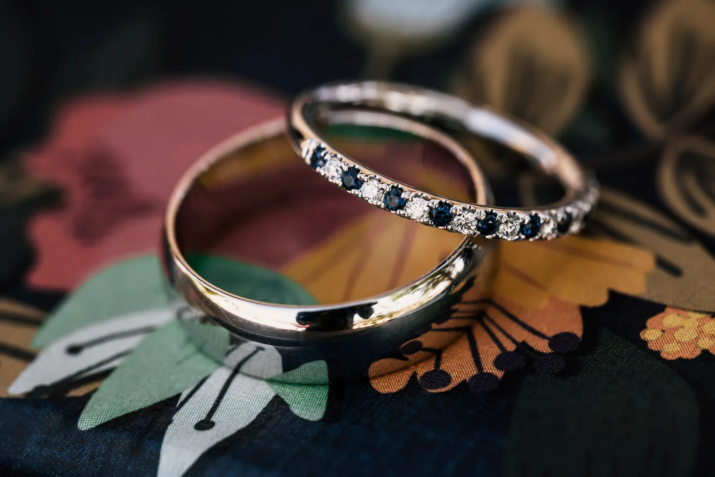 beautiful wedding rings sit atop a floral pattern