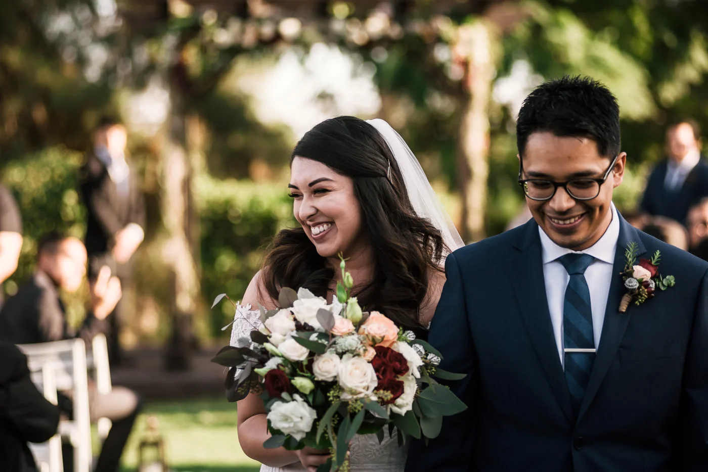 Just married couple happily walks down the aisle after their ceremony.