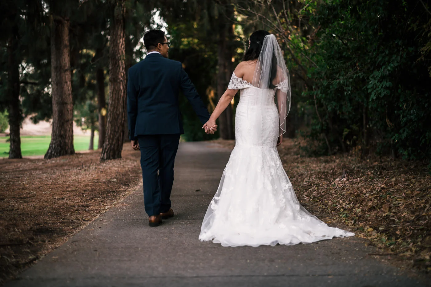 Newlyweds walk hand in hand down the beautiful paths of the Knollwood Country Club.