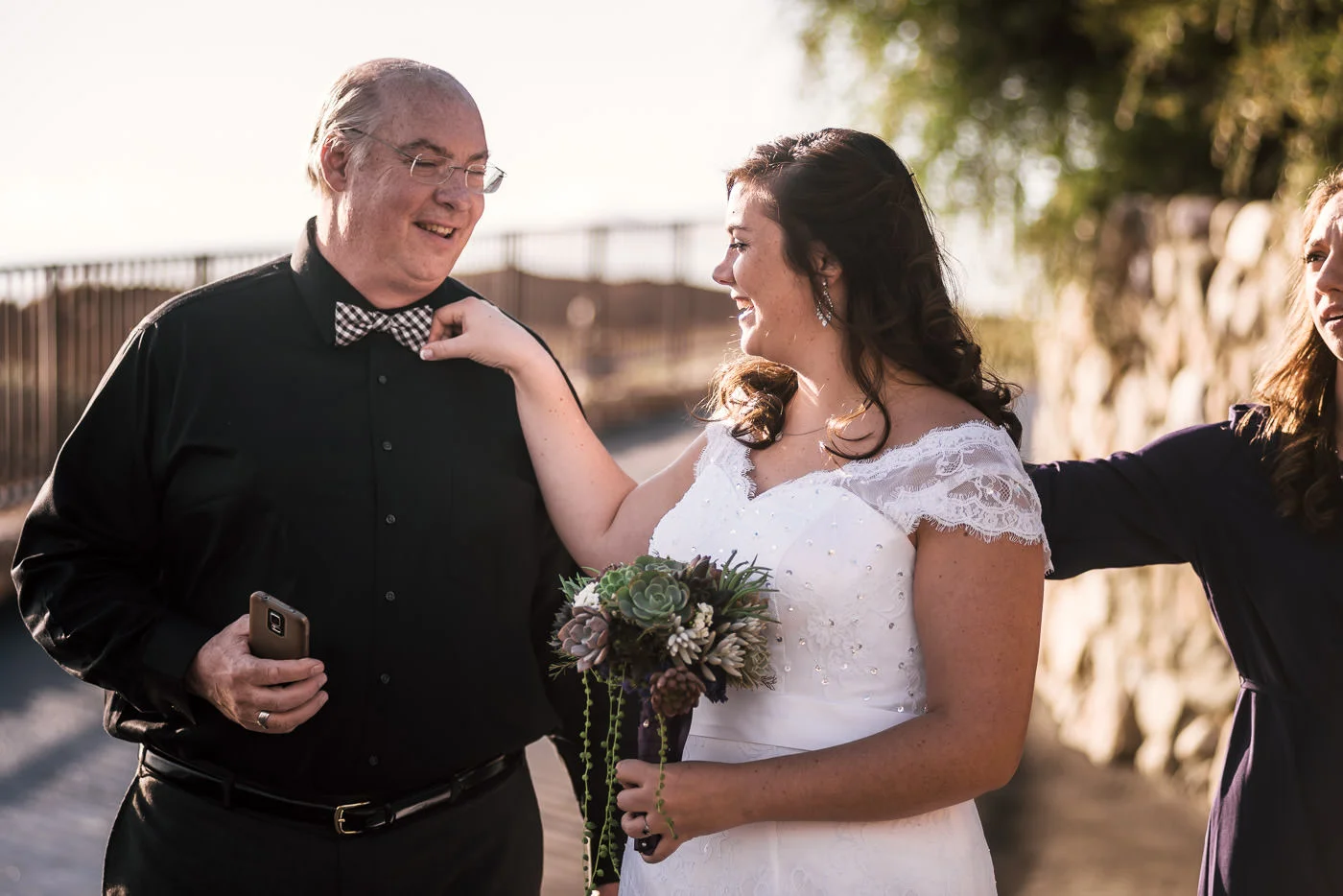 Bride straightens her fathers bowtie before he walks her down the aisle.