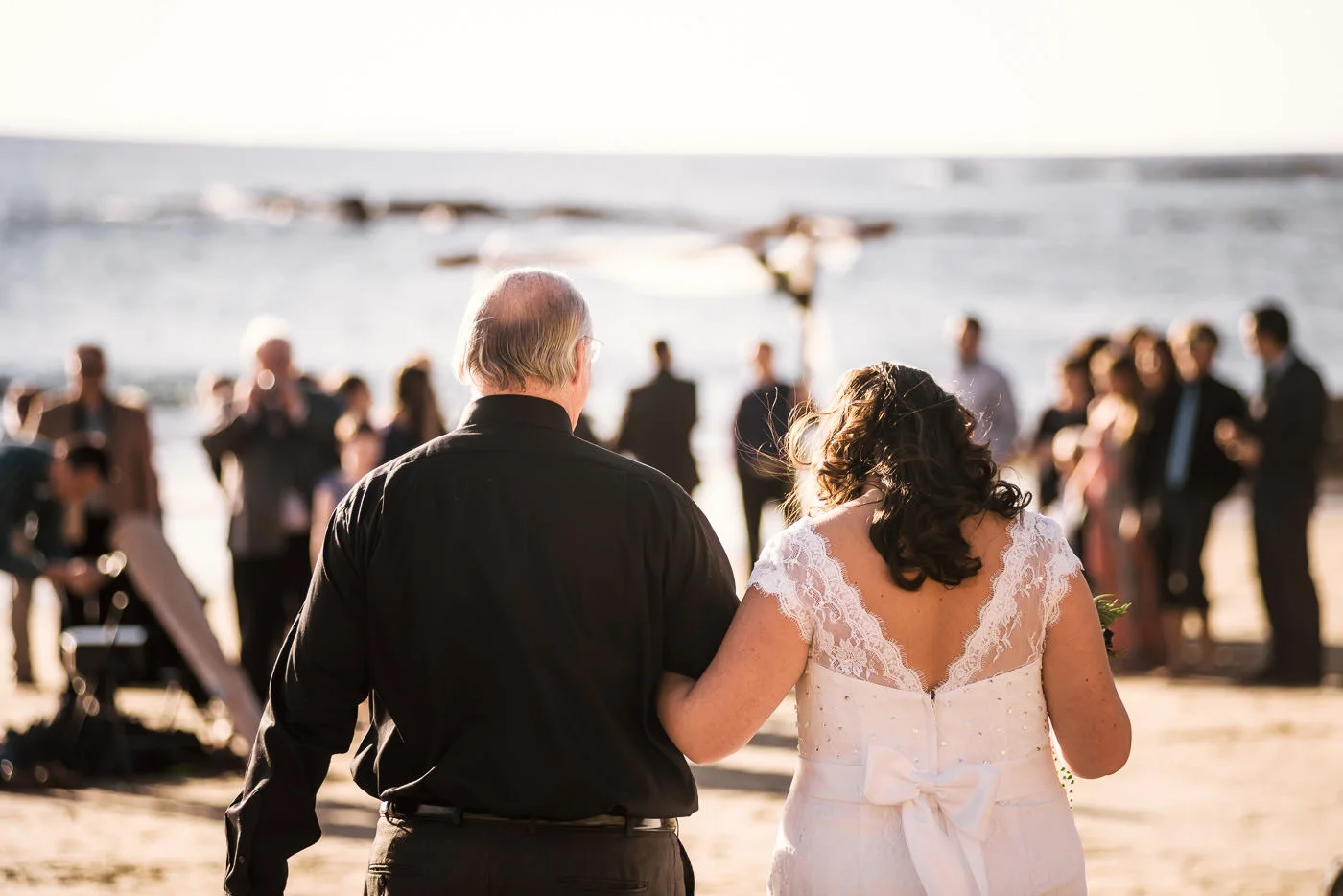 Bride is overcome with emotion as she walks across the sand to her wedding ceremony.