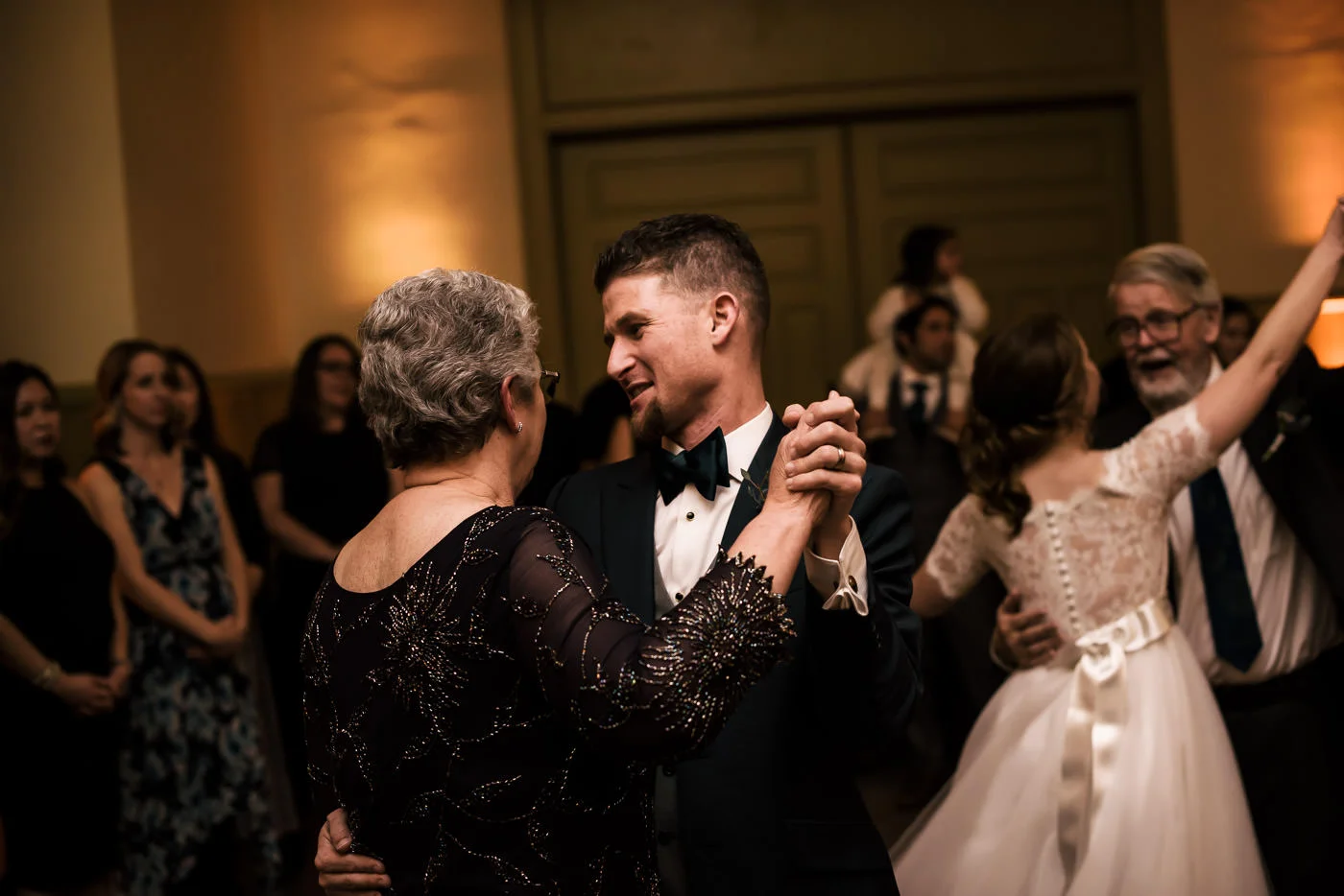 Groom dances with his mother at wedding reception.