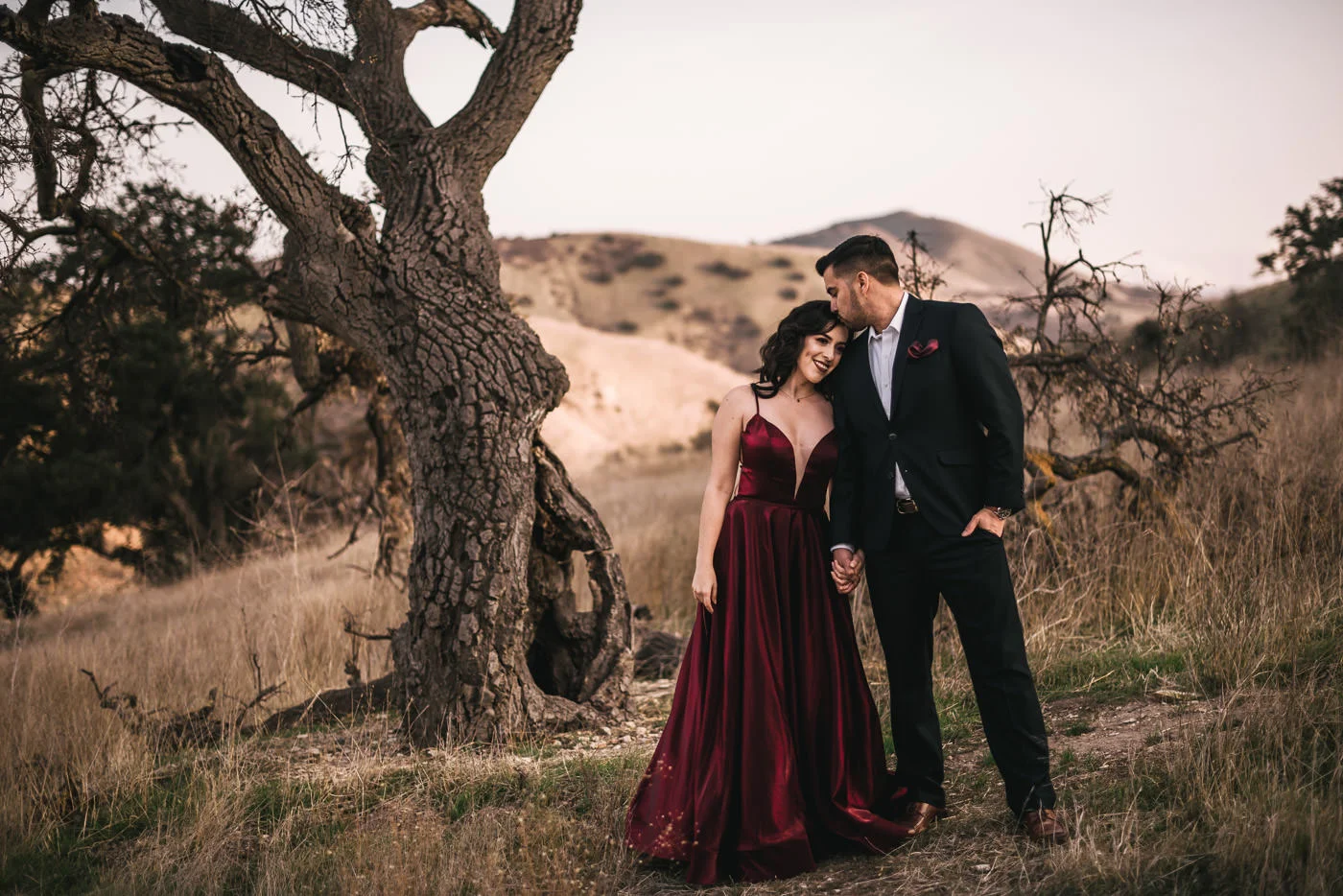 Groom kisses his future wife on the forehead at their romantic engagement session.