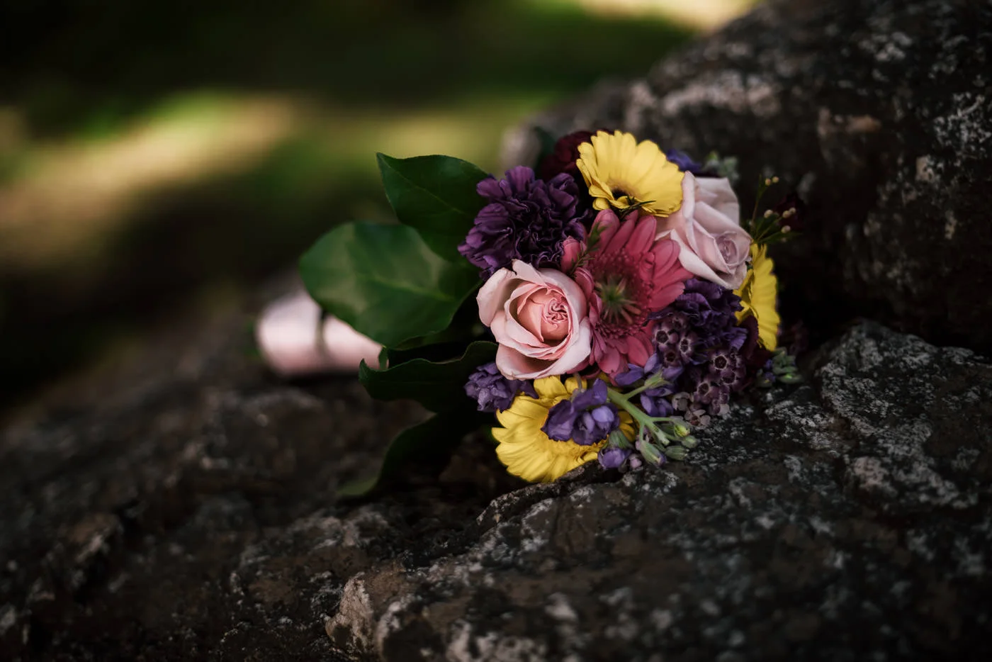 Colorful wedding bouquet sits on a rock in Big Sur.