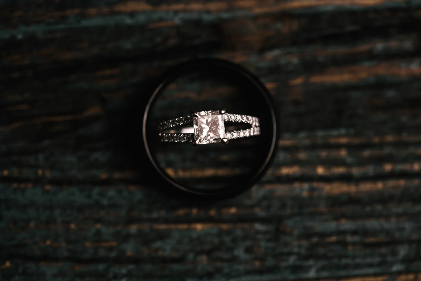 Overhead photo of a diamond wedding ring sitting inside the grooms ring.