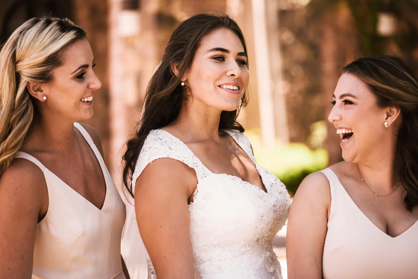 Bridesmaids laugh with the bride before the ceremony.