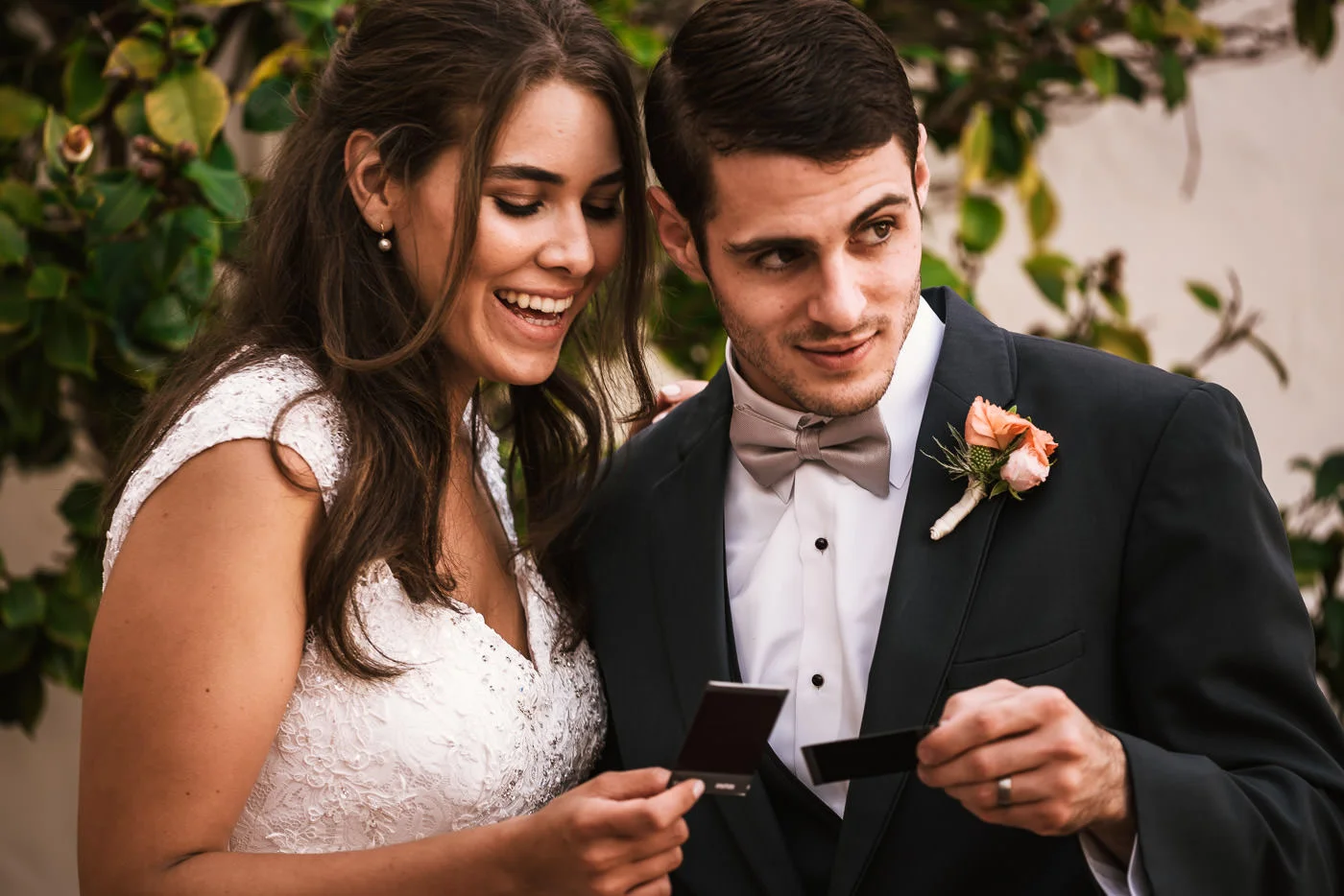 Bride and groom take polaroids of each other and then compare them.