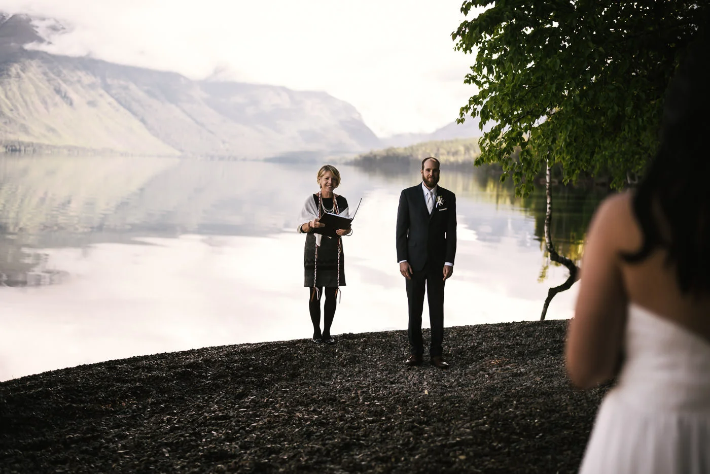 Groom smiles as he sees his bride approach for their wedding ceremony in Glacier National Park.