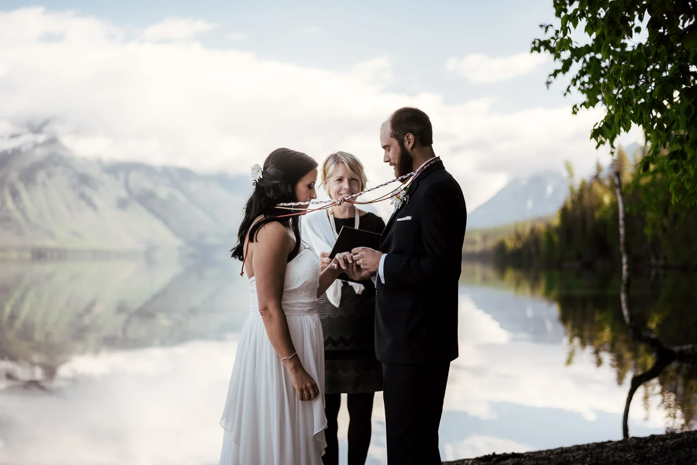 Groom places wedding ring on his new wife's finger at their Montana elopement.
