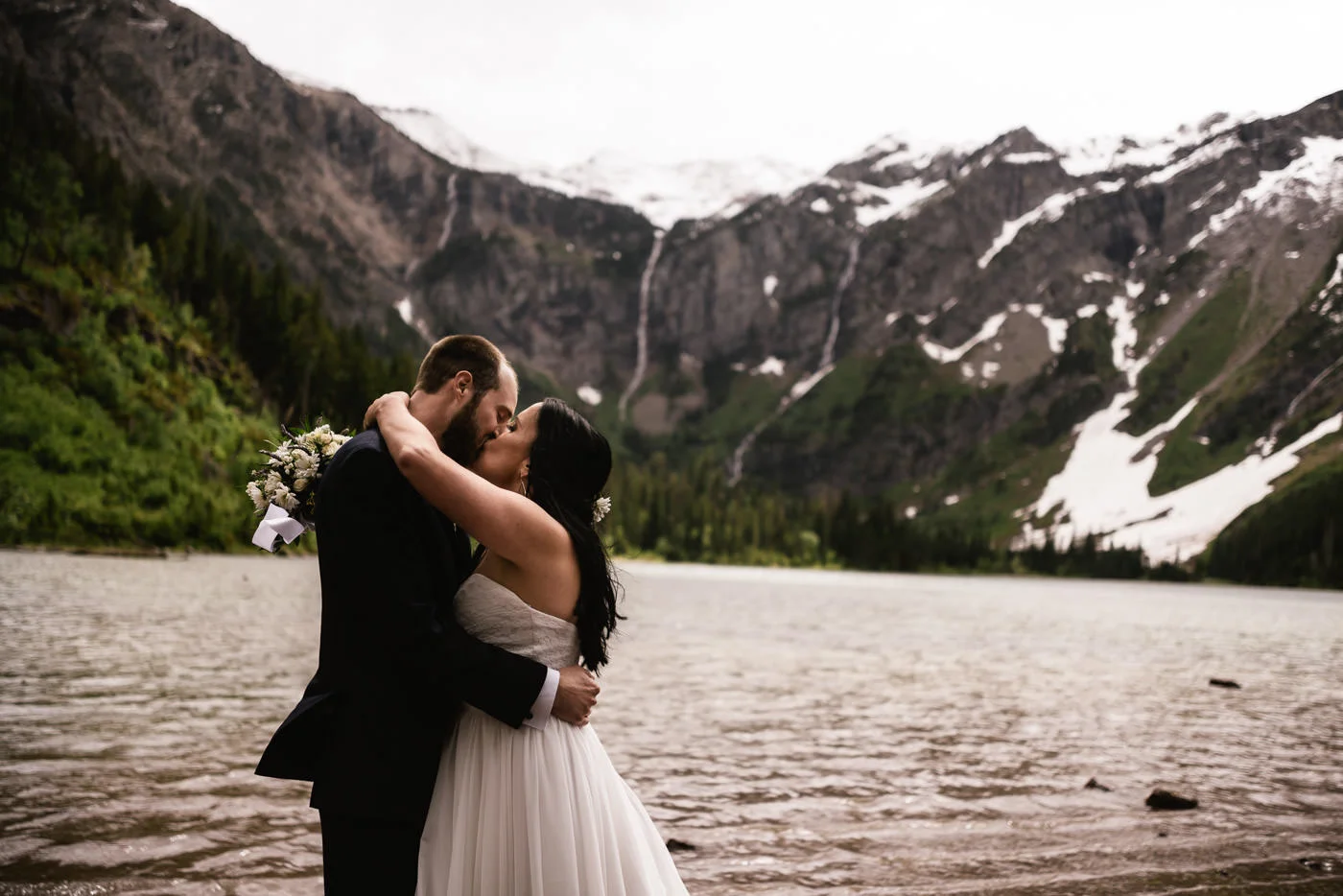 Newlyweds kiss before Avalanche Lake in Glacier National Park.