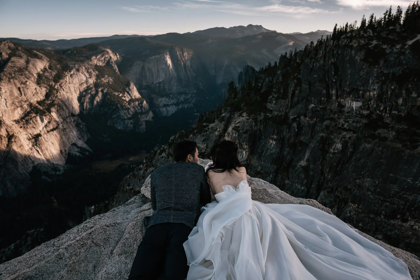 Adventurous couple looks out over the valley below.