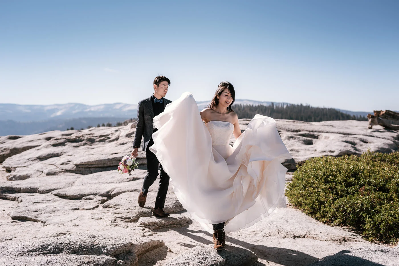Bride and Groom trek across the granite landscape of Yosemite.