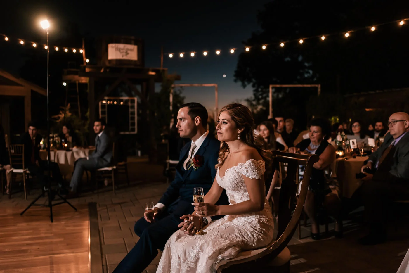 Newlyweds listen intently to the speeches at their reception.