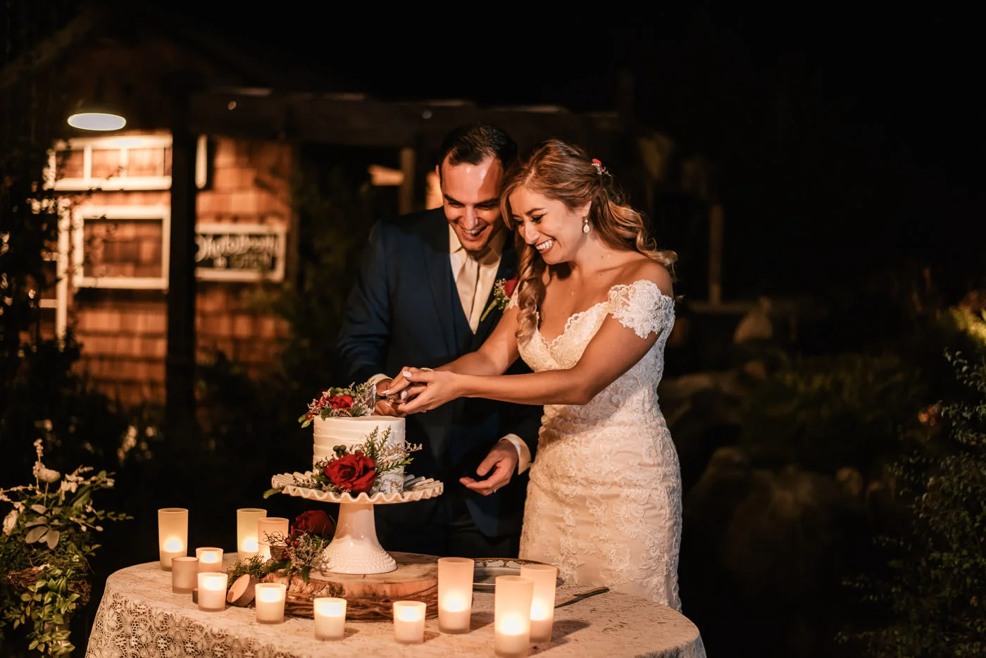 Bride and groom prepare to cut the cake at their reception at The Homestead.