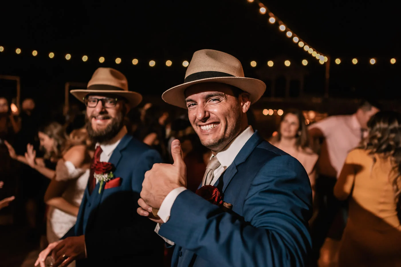 Groom gives a big smile and a thumbs up at the reception.