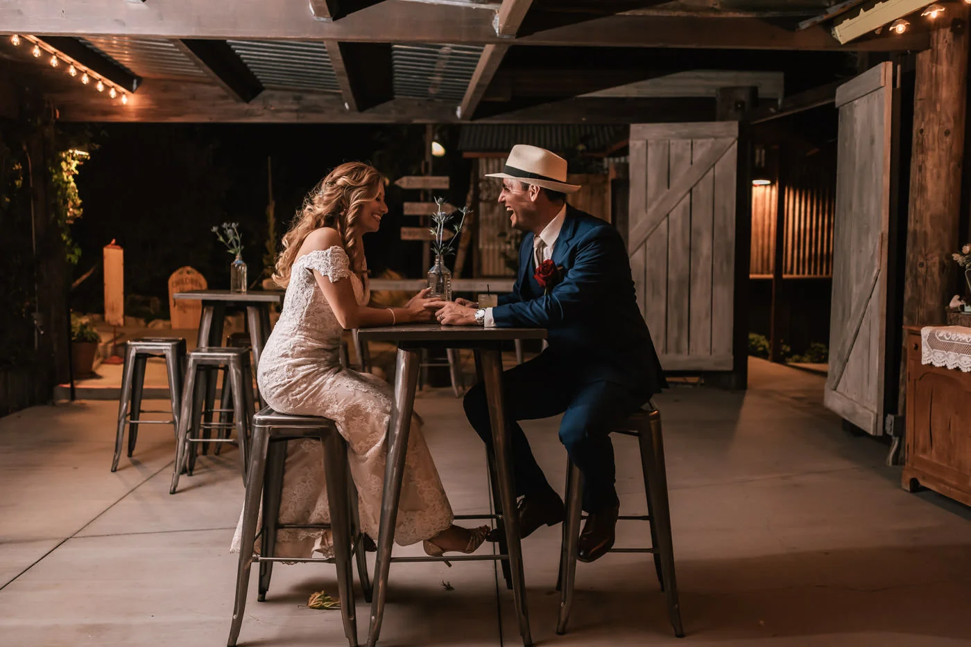 Classy bride and groom take a seat at the rustic bar area of The Homestead at Wilshire Ranch.