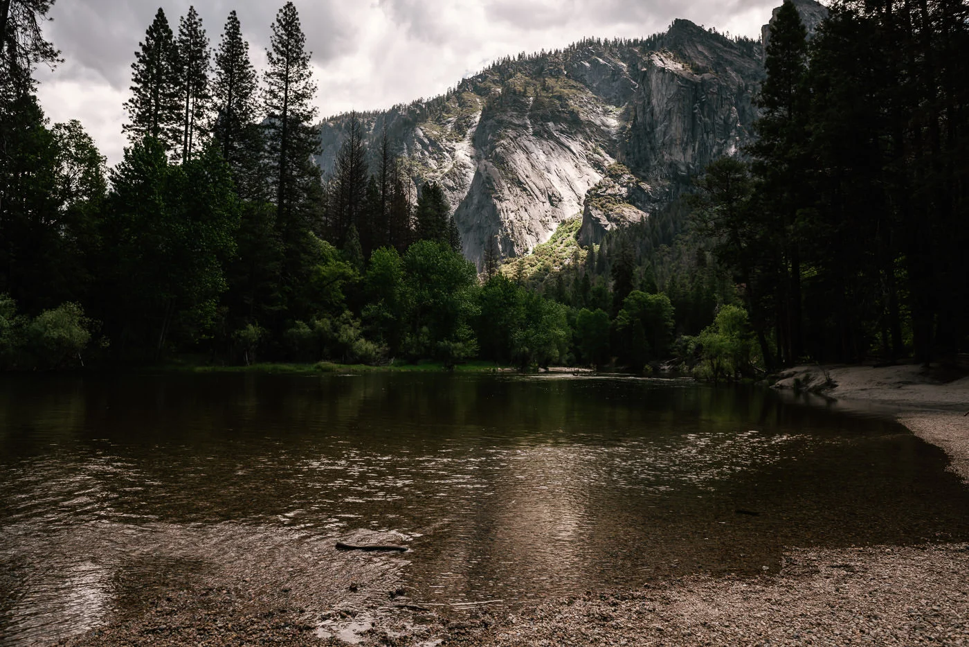 Merced river flows calmly from its source in the mountains past Cathederal Beach in Yosemite National Park.