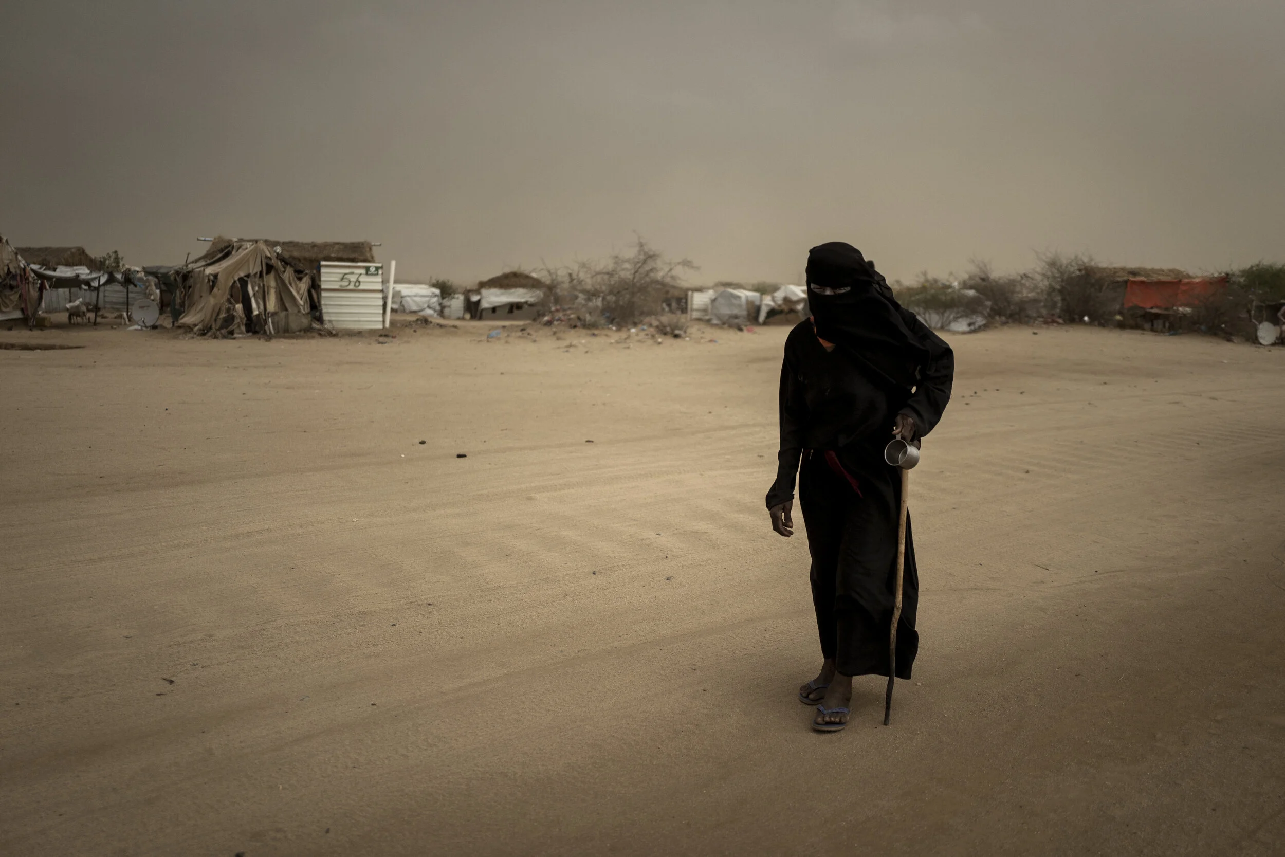 woman-walking-through-outskirts-of-refugee-camp-yemen.jpg
